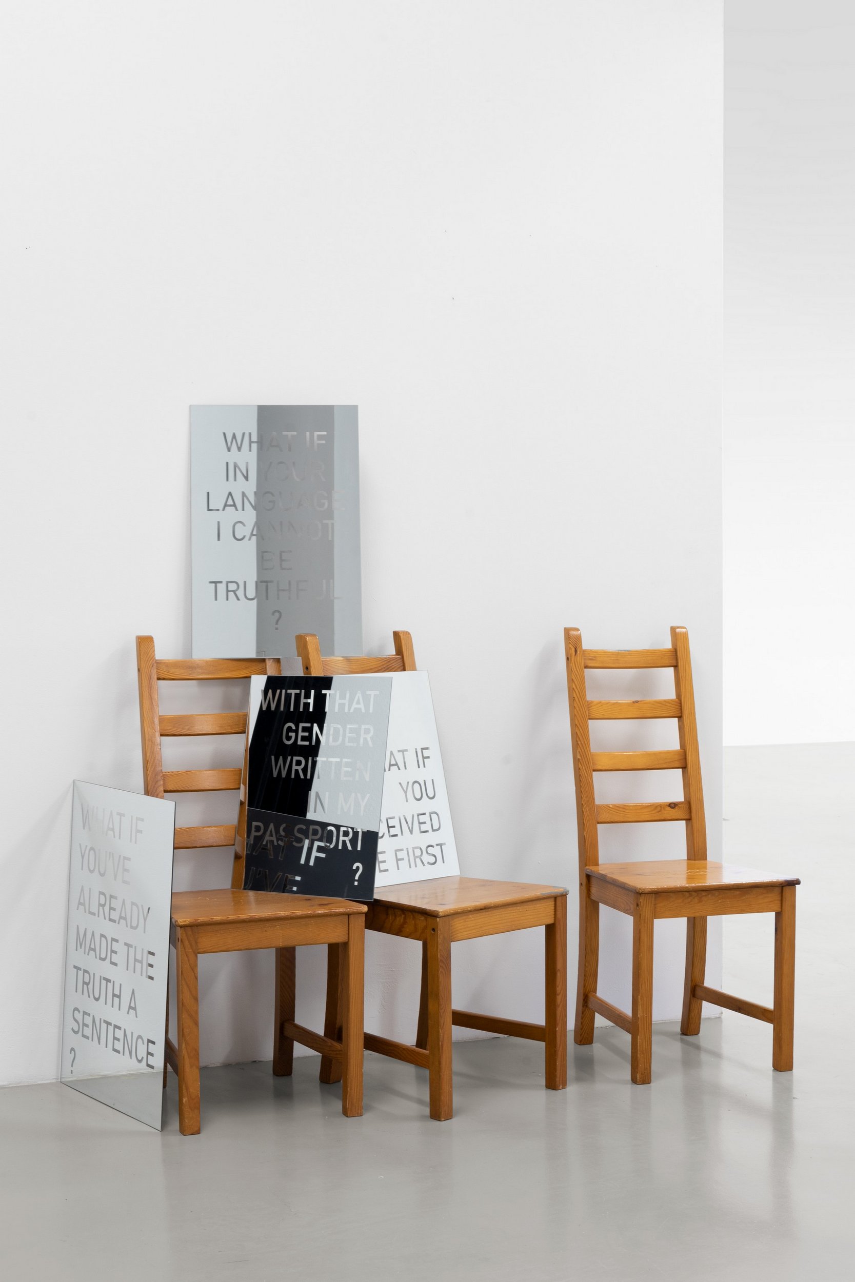 four engraved mirrors resting upon 3 chairs